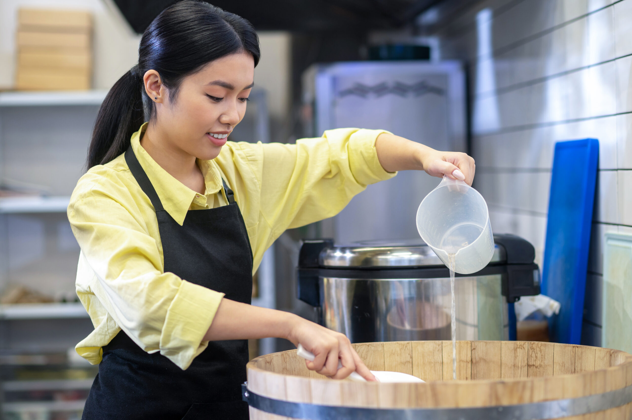 Een jonge vrouw in een keukenuniform bereidt eten, symbool voor tijdelijk werk in de horeca.