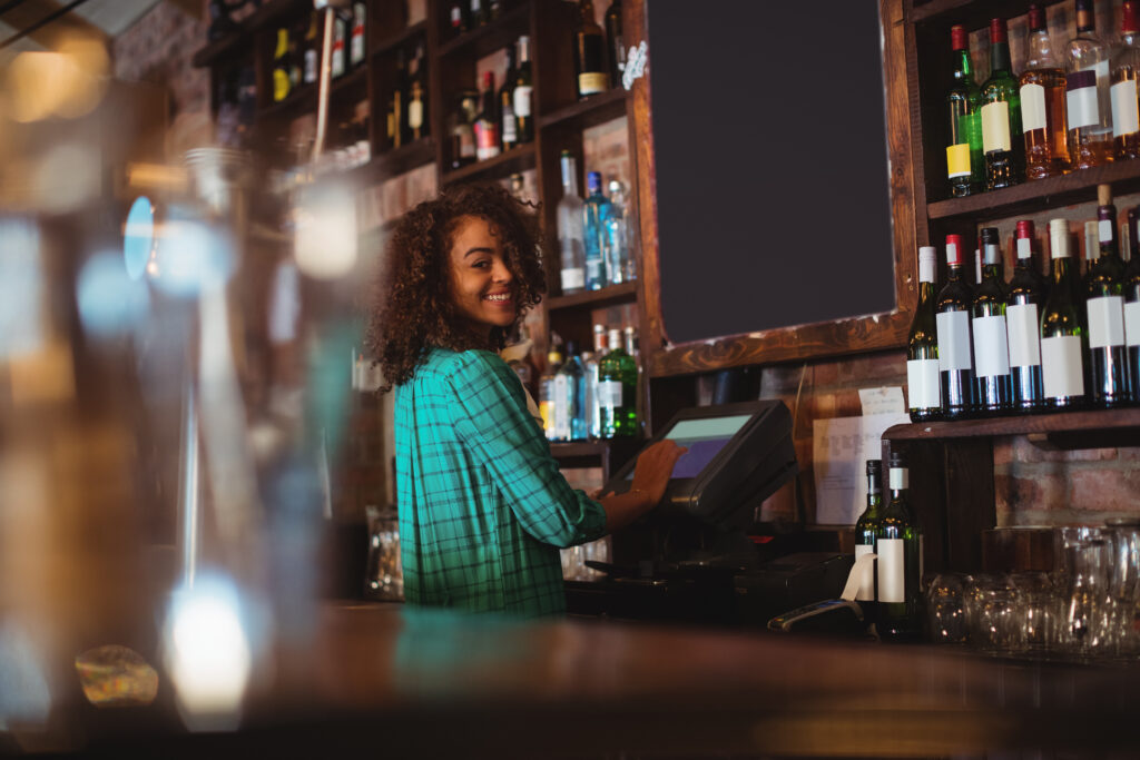 Barvrouw met glimlach in de horeca toont werkplezier via Wijwerken.nu
