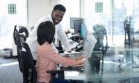 Twee collega’s overleggen op kantoor met een glimlach – symbool voor de persoonlijke begeleiding en samenwerking die Wijwerken.nu biedt aan werkzoekenden en werkgevers.